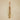 Brass bell wind chime with rose coloured velvet ribbon hanging on a beige textured wall.