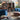 Living room with blue sofas, wooden bookshelf, and decorative items.