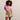Woman wearing a pink top and beige shorts against a plain background