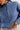 Person wearing a blue pullover with a quarter zip on a plain background