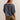 Woman wearing a blue oversized shirt and brown shorts on a beige background