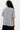 Person wearing a gray oversized shirt with a white background