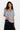 Woman wearing a gray oversized t-shirt and black skirt on a white background