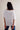 Person wearing a white blouse with a plain background