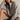 Woman wearing a gray oversized hoodie sitting on the floor against a plain background