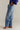 Person wearing blue jeans with a neutral background