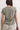 Person wearing a green t-shirt with a visible back pocket against a plain background