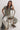 Woman sitting on a rustic chair against a white background
