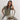 Woman sitting on a rustic chair against a plain background