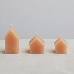 3 sizes of wax candle house in a pale orange colour. 