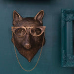 Fox wearing glasses wall mount against a teal wall. 
