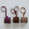 Velvet ribbons unraveled on a textured surface. 