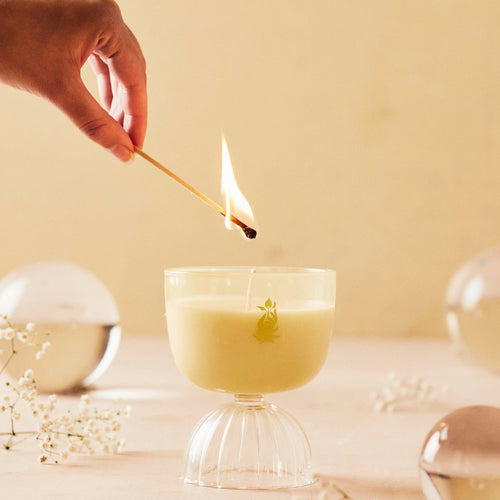 Champagne candle being lit with a match on a table. 