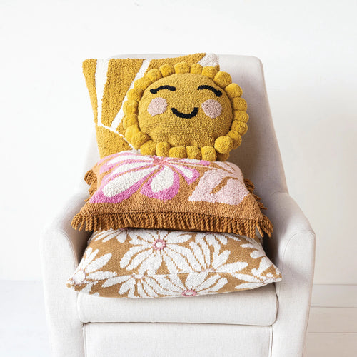 Various different flower themed cotton pillows styled on a white arm chair