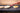 Person using a spatula to flip pancakes on a griddle.