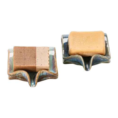 Two stoneware soap dishes pictured with two different types of bar soap.