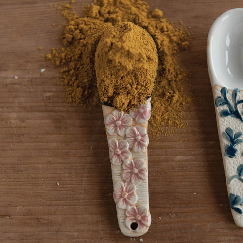 Beautiful hand painted spoon with pink flowers, containing some cinnamon.