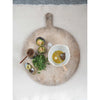 Stoneware bowl and wooden metal whisk styled with a vintage style cutting board with fresh vegetables and herbs.