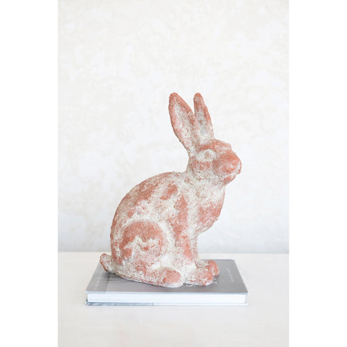 Terracotta Rabbit sitting on top of a book.