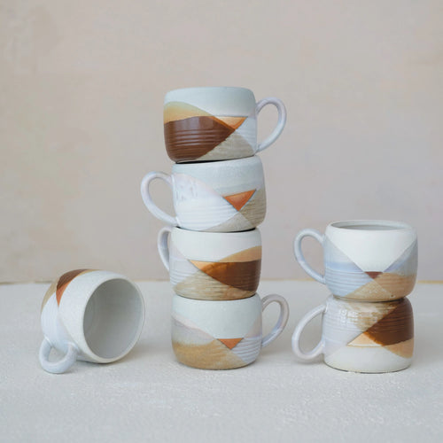 Stoneware Mugs with Design stacked high.