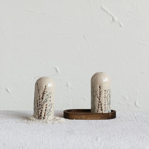 Matching Salt and pepper shakers styled with some coarse salt, sold as a set with an acacia wood tray.