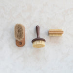 Various different scrub brushes next to the bamboo and polyester brush.