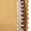 Close up of the beautiful crochet work on the cotton lumbar pillow in the color mustard. 