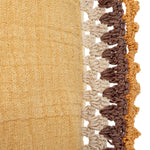 Close up of the beautiful crochet work on the cotton lumbar pillow in the color mustard. 