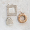 Woven hemp fiber oven mitt and trivet pictured together with a woven decorative hanger. 