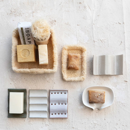 Various beautiful soap dishes styled with different types of bar soap.
