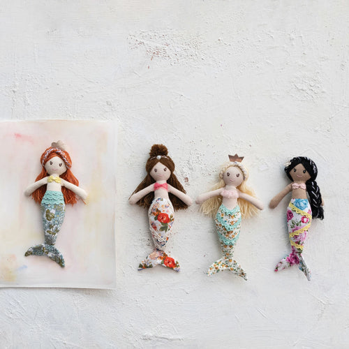 Four mermaid fabric dolls with floral tails styled on a colorful background. 