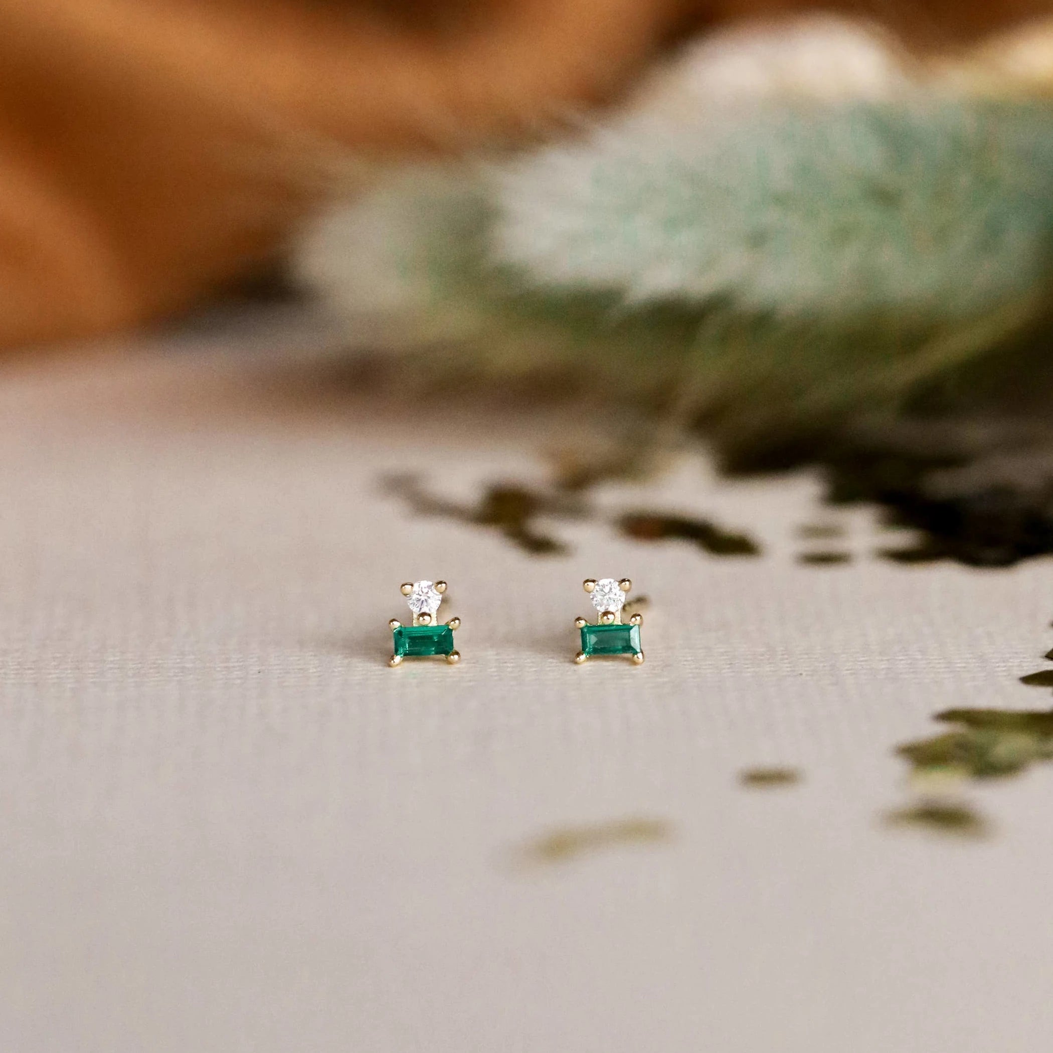 Close up view of the JaxKelly emerald double stud stacked earrings.