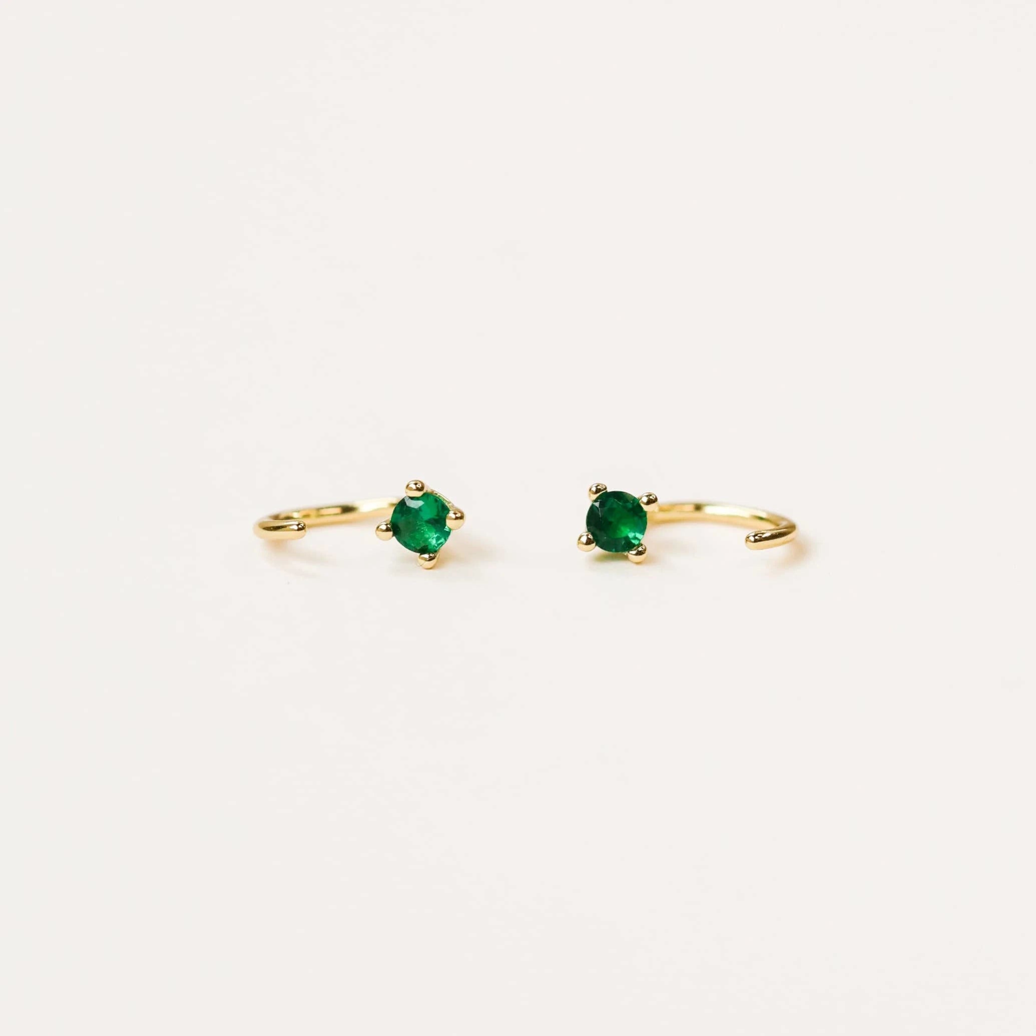JaxKelly emerald colored huggies earrings.