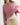 A close-up of a person wearing a dusty pink ribbed knit cropped sweatshirt over a white textured top, paired with beige drawstring cargo pants and a beaded necklace.