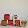 Stacked holiday gift boxes in red and white with gold foil.