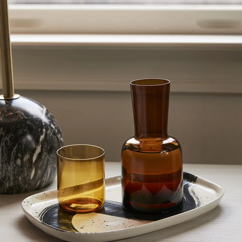 The Keswick Carafe filled with water sitting on a console table. 