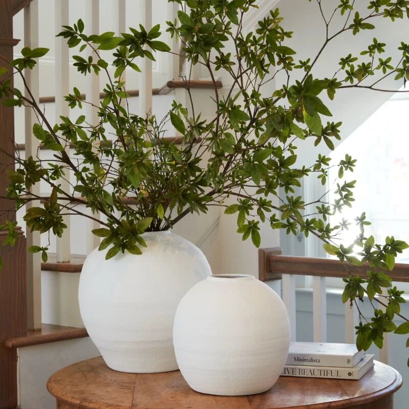 Konos vases displayed on a round wood table. 