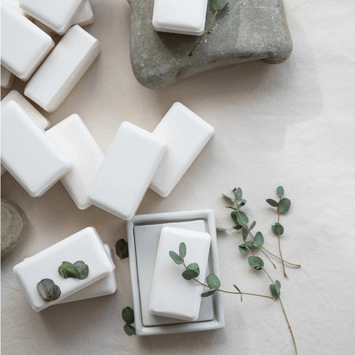Olive oil and shea butter soap made in the USA. Displayed on a table with fresh eucalyptus. 
