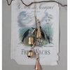 Distressed copper and gold finished metal bell cluster with wooden beads and jute string infront of a vintage poster.