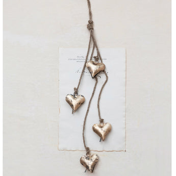 Antique brass finished hearts hanging on a jute string.