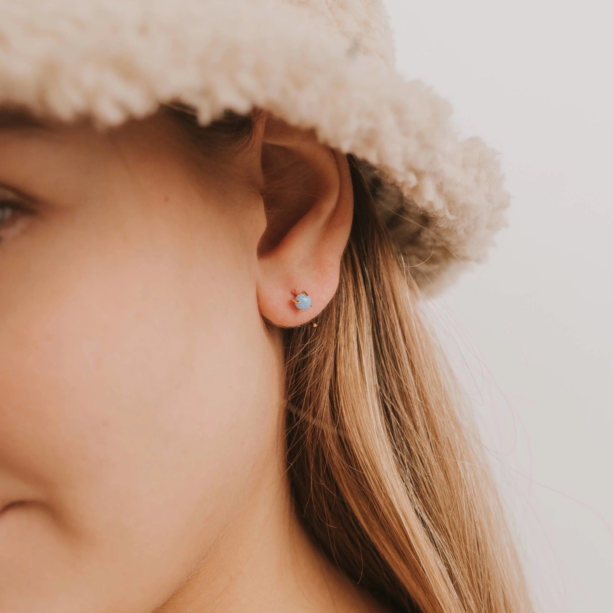 Model wearing the opal joy huggies earrings. 