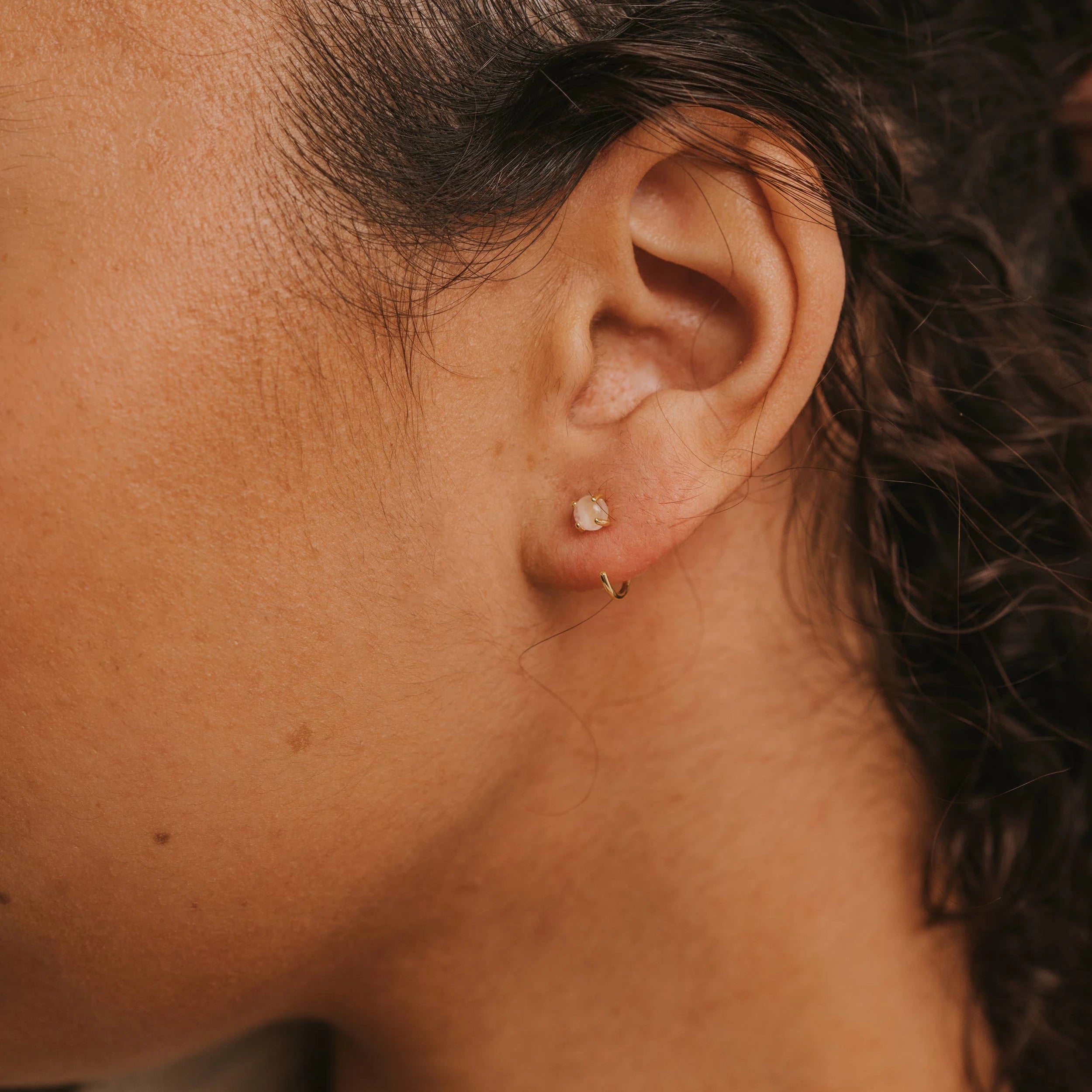Model wearing the rose quartz huggies earrings. 