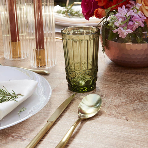 Mossy green coloured drinkware on a tablescape filled with fresh flowers and candles. 