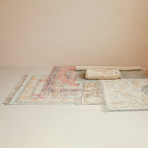 Multiple unique distressed print rugs stacked on top of each other. 