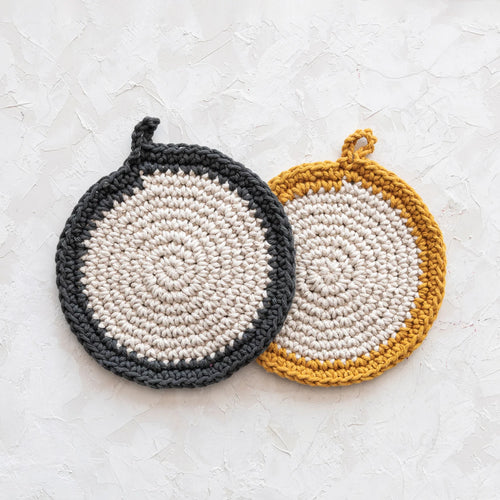 Creamed coloured round crochet potholders with dark grey and yellow trim. 