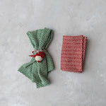 Green and cream woven tea towel wrapped with ornament ready to gift. 