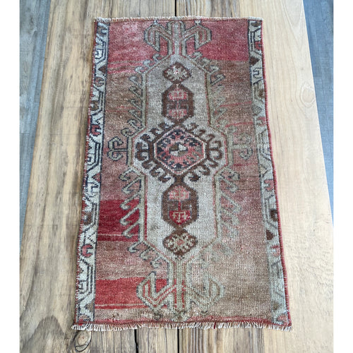 Turkish area rug in a rich deep pink, pale pink, beige, brown with hints of blue gray.