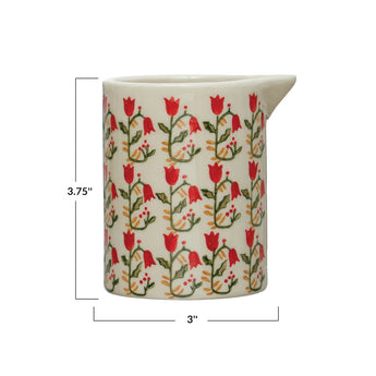 Stoneware creamer with painted red flowers.