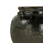 Details of the handle on a glazed black clay pot vase. 