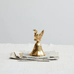 Brass Bell with Turkey on top of loose paper. 